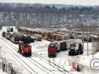 On a dull and dreary day, I get a lucky catch with three working jobs in the SOR/CN Hamilton  Yard. CN 556 has just arrived with a cut of cars and is preparing to return light power back to Aldershot. SOR 494 (Afternoon yard job) is cutting ahead of the day job (SOR 493) as both have work on the N&NW spur in north Hamilton.