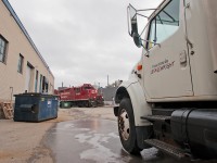 Appearing out from behind the building, CP 8250 leads a GP40 after switching Polytainers. 