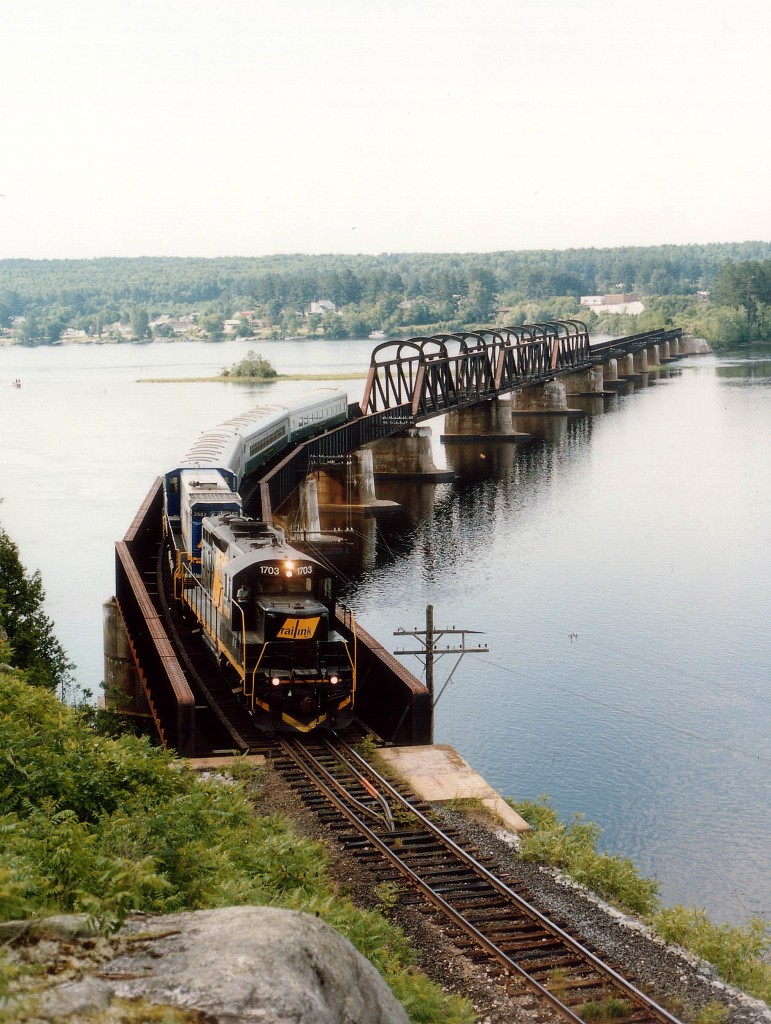 Shown as Mattawa, ON., we are actually on the other side of the Ottawa River (Rivere des Outaquais)in an unpopulated area of Quebec. Power on this northbound Mattawa-Temiscaming Excursion train (Timber Train) is OVR 1703 & the Timber Train's 3582. This service never caught on, and ran only 3 years. The 3582 ended up on STER, and that too folded.