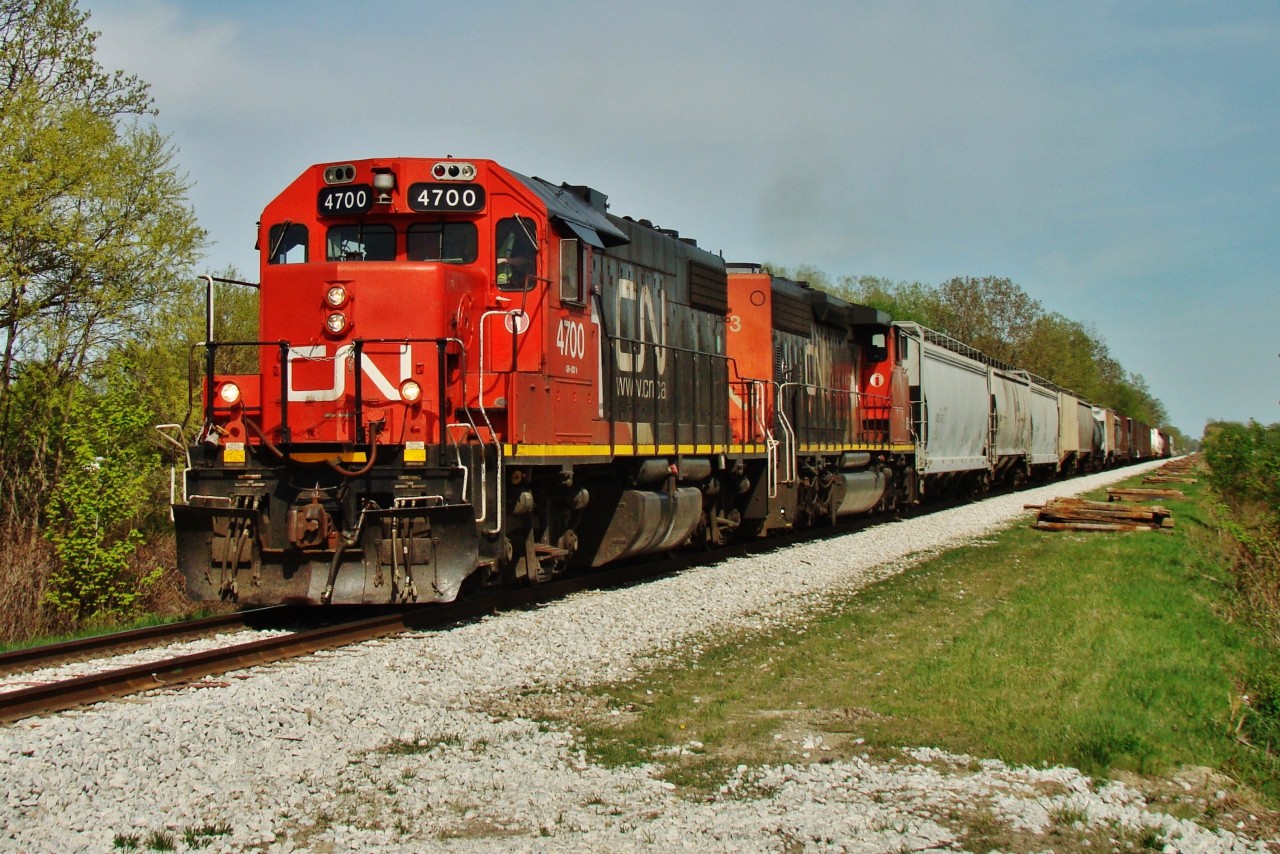 After stopping just back in Puce due to a brake line issue, CN 439 lead by a GP38-2 and a widecab SD40-2 have returned to track speed as they head into Windsor along VIA's Chatham sub.