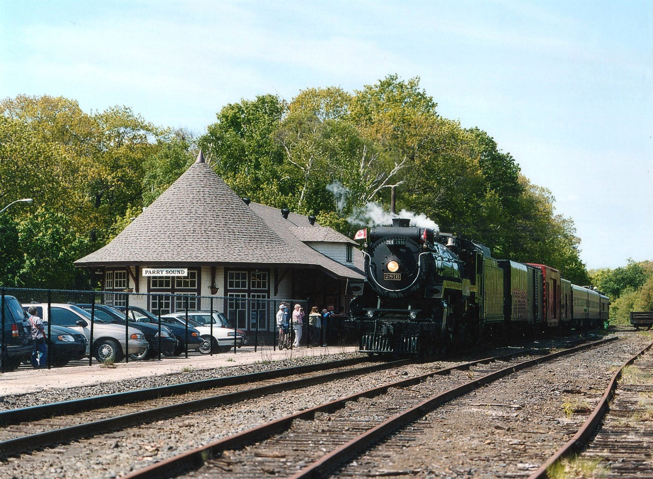 During CP's 'good-will' steam program, the CP 2816 made an appearance throughout Southern Ontario in the early summer of 2003. In this image, she is shown stopped at the old Parry Sound CP station, now renovated and born anew as a Gallery. A few fans were on hand for photos, most others were down in the dock area waiting for their chance at capturing shots of the train southbound over the popular Parry Sound trestle. At the completion of the tour, this train returned via the same route on June 22nd. Currently the locomotive is out of service, and the rumour mill says it is up for sale.