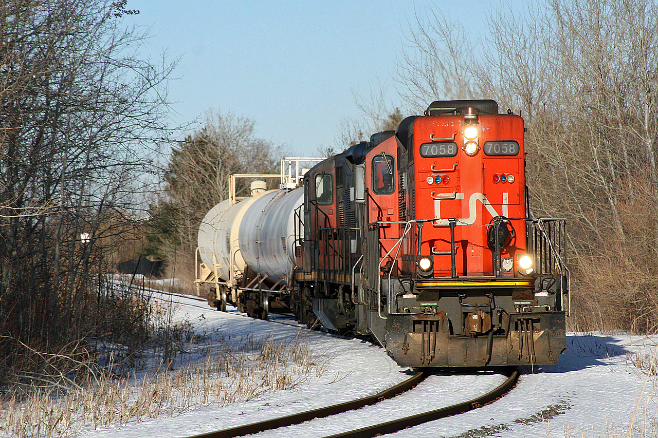 CN 556 eases into the tight curve before crossing Ford Drive, nearing the end of their slow trek down the St. Lawrence Cement Lead, with two tanks cars in tow.