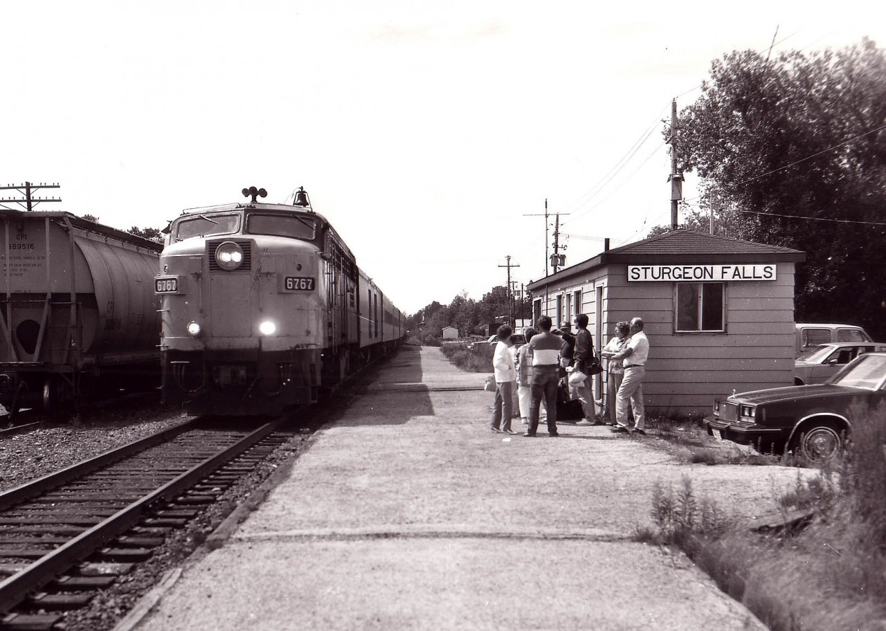 Of course typical government cutbacks have managed to eradicate this once common scene forever, but back on a warm day in 1987 here is proof people rode the train; even from a scaled down facility such as this. The last time I visited this little stop before the passenger was discontinued; the waiting room had no phone, no heat,(or A/C) no timetable and filthy graffiti covered walls and one soiled bench to make the traveler feel at home. In order to find out how late the train would be,a note pinned on the wall suggested the rider check with the travel agency downtown...but you had better have your own phone..... It is a wonder some passenger routes hung on as long as they did. This image is of the Montreal portion of the 'Canadian' with VIA 6767 sole power. There isn't even any track east of Mattawa any more............