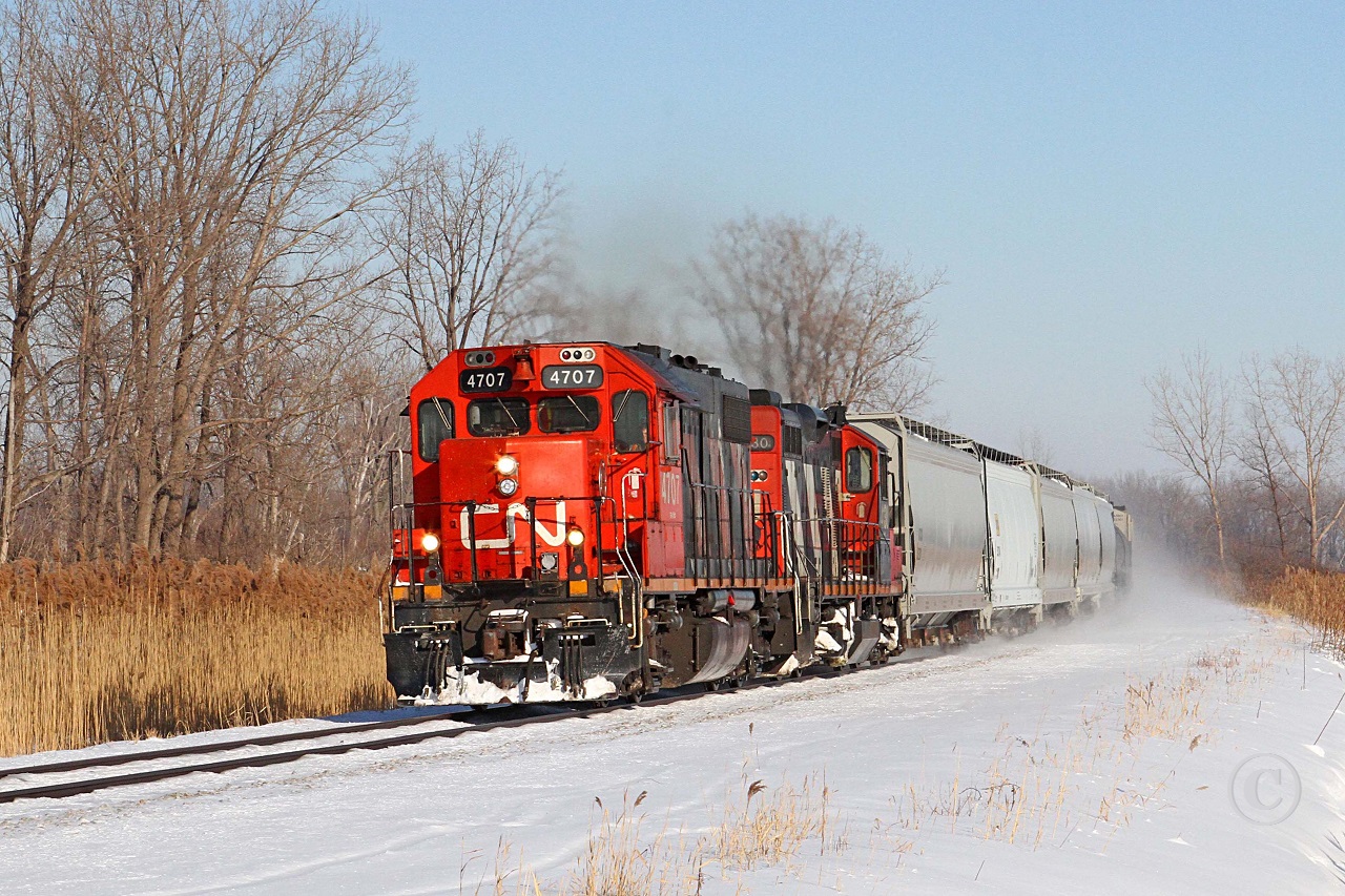 A fine winter day sees CN 4707 and 4130 in charge of Windsor bound train 439 on the curve at Lighthouse Cove, mile 77.3 on the VIA's Chatham Sub.