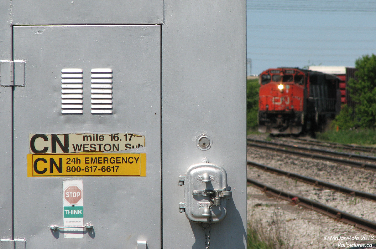 The Signal Bungalow Tells All. Making their way 'round the bend to head down to CP Lambton Yard, after departing CN's Malport Yard, a pair of GP40-2LW units inch train 577 to the crossing at Torbram Road, Mile 16.17 of the CN Weston Sub.