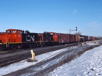 CN 1127 and CN 1124 lead a transfers out of Portage Jct, complete with an International Service caboose.