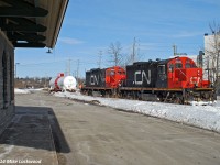 Framed by Port Hope's classic 1850's era Grand Trunk cut granite station, CN 7039 and 7000 have completed swapping out one inbound tank for one outbound at Cameco. All that remains for the crew is to tie onto the outbound and push east to the small yard at Cobourg, where they'll will go off duty and taxi back to Belleville. 1453hrs.