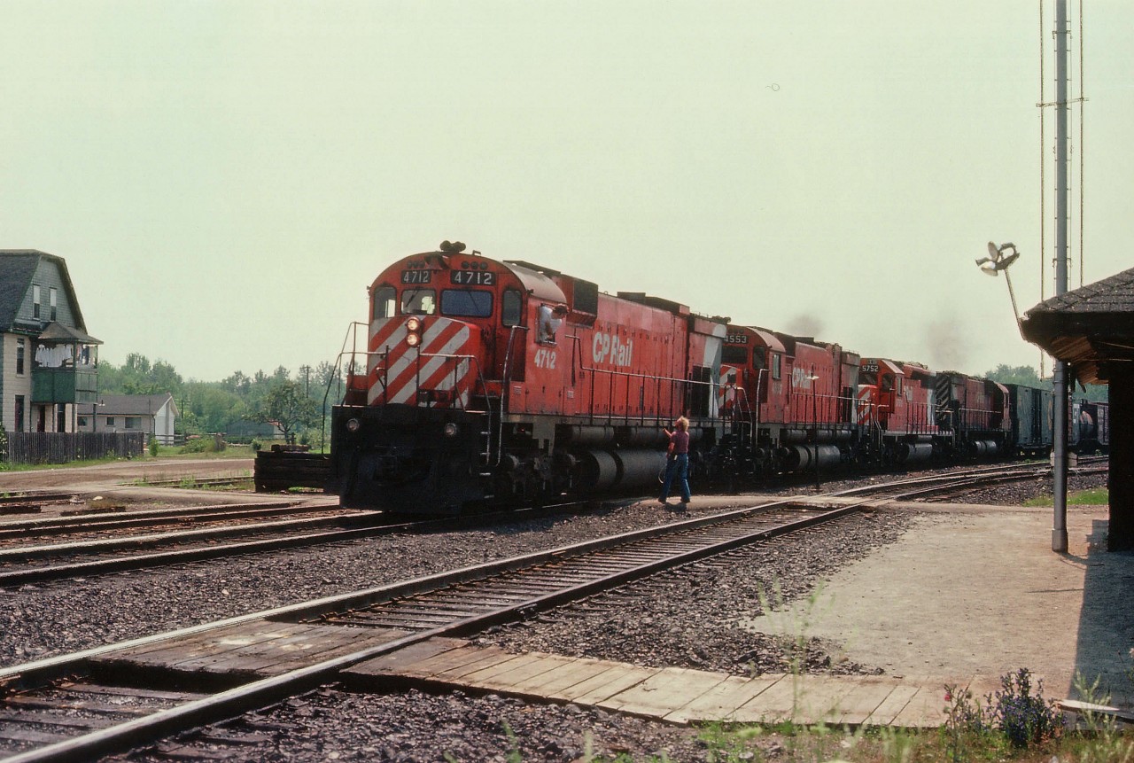 A harsh overhead sun was the reason I elected to shoot from this odd angle at Guelph Jct. The only clue that this is an image from the Jct is the building on the left; perhaps a former hotel or boarding house. It is still in existence. Everything else is gone. The station and the power. The most distant track in the photo was removed this past fall, and the rest has been rebuilt (elevated). CP 4712, 4553, 5752 and 4508 roll eastward as the orders are hooped up.