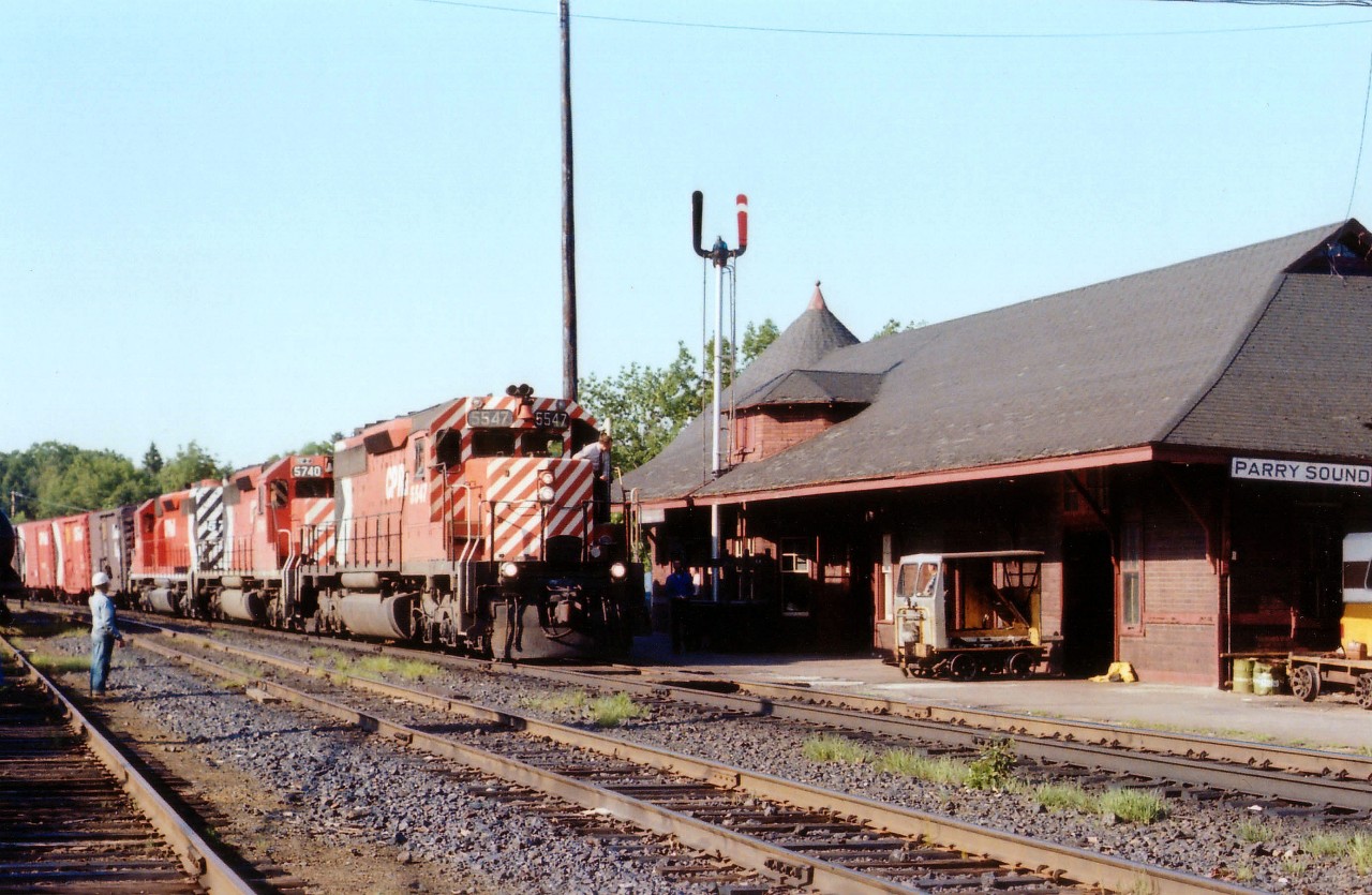 This was a favourite Parry Sound location of mine during the early morning hours until the late 1980s when the trees off to the left grew to such size that shadow was cast over the scene. In this view CP 5547 in its 'as issued' paint scheme leads sisters 5740 and 5739 northward toward Sudbury as MoW workers prepare to watch roll-by. The arrival of each train at this popular station was almost like a social gathering. The old station lost its' status in the 1980s, closed,was almost lost, but was rescued and rebuilt as a "Gallery". But trains don't stop here any more.
