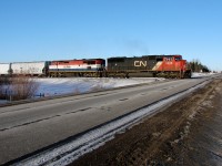 CN 5608 and BCOL 4602 cross Range Road 231 as they travel East on the Wainwright Sub.