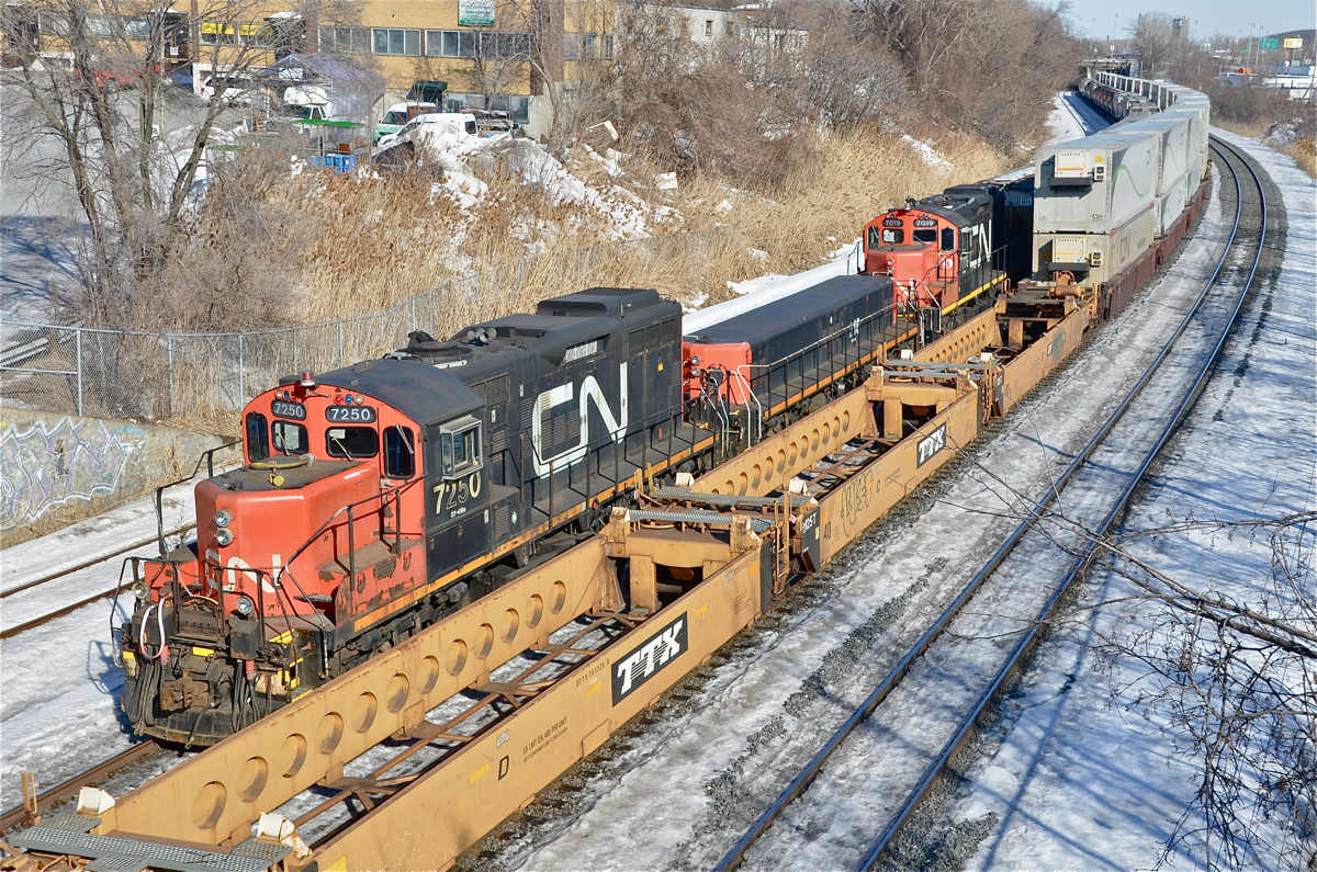 A GP9/slug/GP9 trio (CN 7250, CN 218 & CN 7019) are stopped as CN 120 passes on the right. This train was hauling damaged cars from a derailment that occurred a few miles east of here overnight involving a sideswipe between CN 121 and a local switcher. For more train photos, click here.