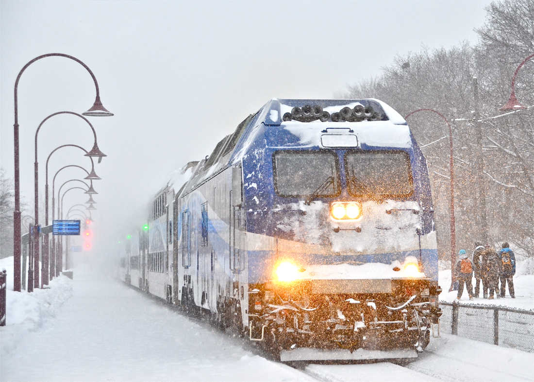 While a number of students await their train on the opposite platform, a very snow covered AMT 1359 leads a deadhead movement eastwards through Montreal West station during a very windy snowstorm. For more train photos, click here.