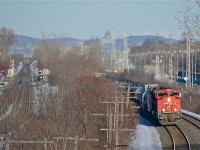 CN 8857 & CP 2681 head west through Beaconsfield with a westbound train, possibly CN 377. At left is the CP Vaudreuil Sub and AMT's Beaconsfield Station. In the distance is Mount Royal, with St. Joseph's Oratory visible in the middle right background. For more train photos, click <a href=http://www.flickr.com/photos/mtlwestrailfan/>here.</a>
