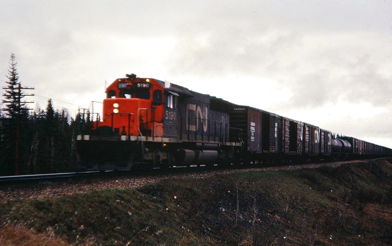It's a gloomy wet afternoon in May 1973 as CN 5190 is in charge of a westbound mixed freight near Edson, Alberta.