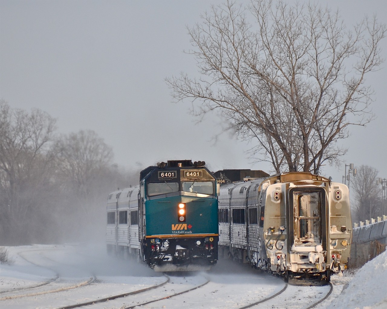 Meet at (slow) speed. At left VIA 6401 is heading west with VIA 67 and is slowing down for its station stop at Dorval. At right, VIA 6404 is leading VIA 52 eastbound after making its station stop at Dorval. For more train photos, click here.