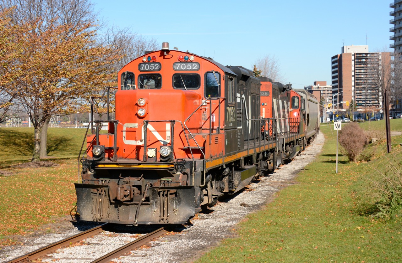 CN7052 leads CN4136 through Sarnia with hopper cars from the Cargill grain elevator.