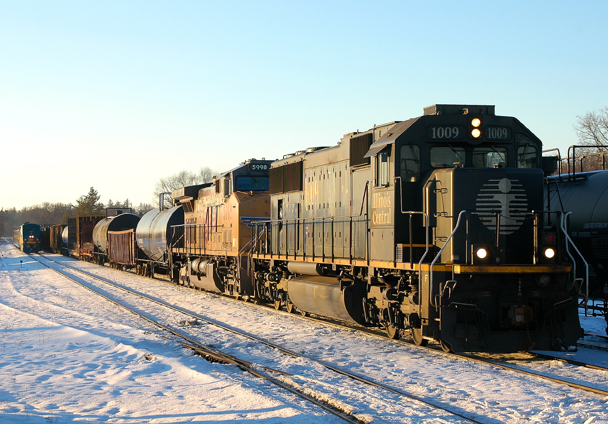 IC 1009 - UP 5998 lead 330 through Brantford on the north track. A late running #76 with VIA 903 leading can be seen arriving for it's station stop on the south