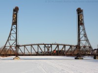 Trillium Railway locomotive number 110, leads a single gondola over the Old Welland Canal and across an old lift bridge.