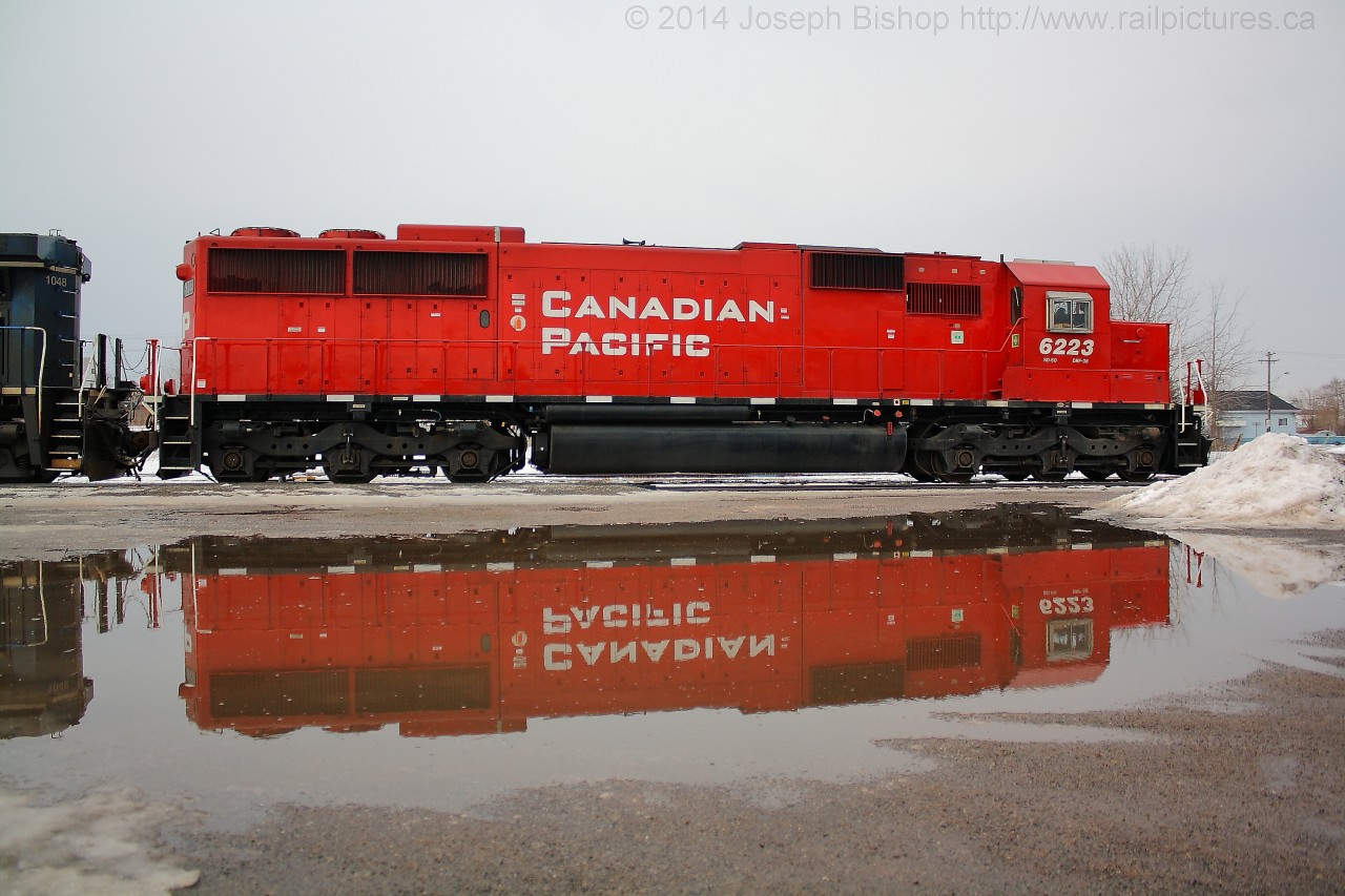 CP 246 had to stop at Fort Erie and wait for clearance from the CSX dispatcher to cross the International Bridge.  Their power was CP 6223 and CEFX 1048, where they stopped allowed for me to capture this shot of an almost perfect mirror image of the rebuilt SD60 in a freshly made puddle from the mild temperatures that day.