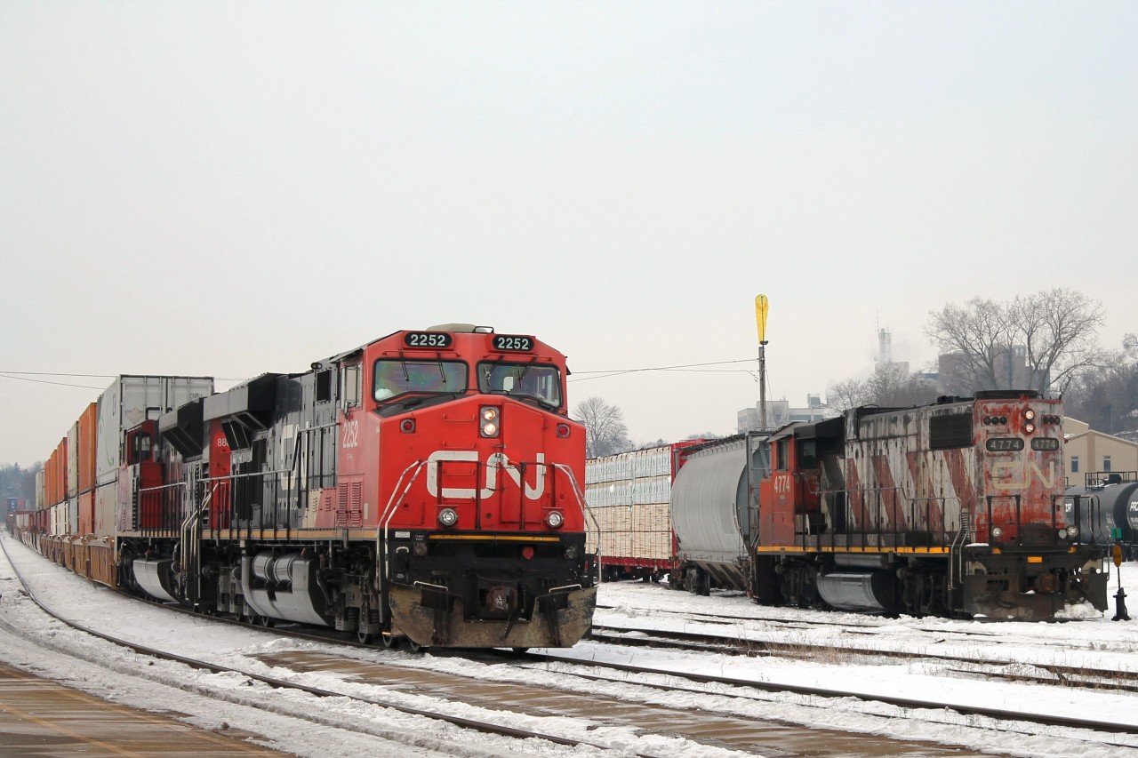 Just after 11am CN 2252 and 8889 crawl through the station before picking up speed. This train, possibly 148, was all intermodal and is passing 4774 which is waiting to take a lumber load down the branchline.