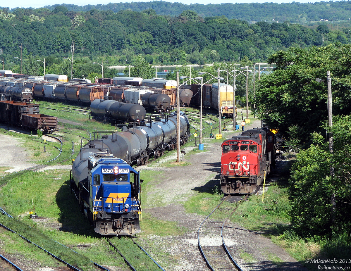 Working the Stuart Street yard in Hamilton, Southern Ontario Railink GP38-2 3873 shuffles a cut of tank cars around on a sunny day, surrounded by all the lush greenery of the waterfront. Starting out her career on the Maine Central railway (MEC), 3873 previously worked on RailAmerica's Ottawa Valley Railway as their 2000 before coming here. Parked a few tracks over is another GP38-2, CN 4776 (GP38-2W), which along with GP9RM 4121 is being leased from CN for use by SOR.