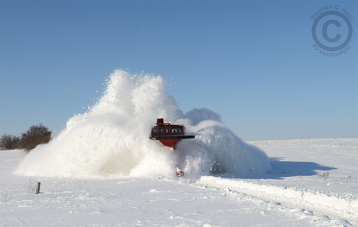 The infamous Salford Cut and a lesson - one of the most notorious spots for drifting on the Port Burwell sub  located just north of the OSR Shops in the middle of a farmers field. Even though a train had been through this spot earlier for CAMI and the plow of the locomotive would clear the right of way, the plows flange blades and wings heave considerable amounts of heavy wet snow 20 plus feet into the air. Seconds later I was hit by two waves of snow as I bravely turned and ducked - the first wave -  snow from the flanger blades is lifted from inches below the rails and thrown by momentum along the sleek plow curves - hit me like a thousand smowballs thrown in my direction. However, the second wave - from the mighty wings of the plow - each outstretched to their limit, flings snow forcefully to each side - this second wave hit me with a mighty wallop. Gravity won this round and like so much snow before it, took me to the ground, temporarily. Moments later I rose from the snow to watch the train finish the cut, and back up to take a second pass, to which I stood further back in awe of the mighty power that I had just witnessed.