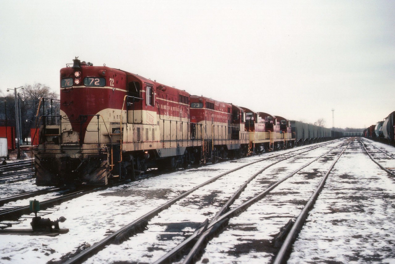 Phosphate rock from Florida was delivered by CP to Aberdeen Yard in west Hamilton for the TH&B to deliver it to International Minerals and Chemical Corp. in Port Maitland in the 1980s. Here we see the train ready to depart the yard as soon as the crew gets on board. Power shown is TH&B 72, 73, 57, 51 and 55. Whatever was available was pressed into service to tackle the 1% grade to top the escarpment at Vinemount.