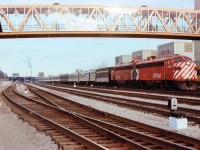 There were a lot of changes when the first new VIA schedule was issued to go into effect October 29, 1978. CN and CP passenger equipment was now shared now that the fledgling VIA RAIL corporation was organized in order to take control of the faltering CN and CP passenger trains. The "Canadian" was now originating/terminating at Toronto on its daily run, destination Vancouver, as trains #1 and #2, while the Super Continental, daily departed Montreal to Vancouver and return as trains #3 and #4. This image, taken from just west of the CN Tower walkway, is of the very first of those "Canadian" passenger trains that have become so popular over the years. Power up front is CP 4066 and 4067, with a CN steam jenny and a CN coach partway back, in an otherwise solid CP consist. Departure point Union Station can be seen in the background. A few pedestrians, possibly uninformed as to the historical significance they are witnessing, watch from overhead.