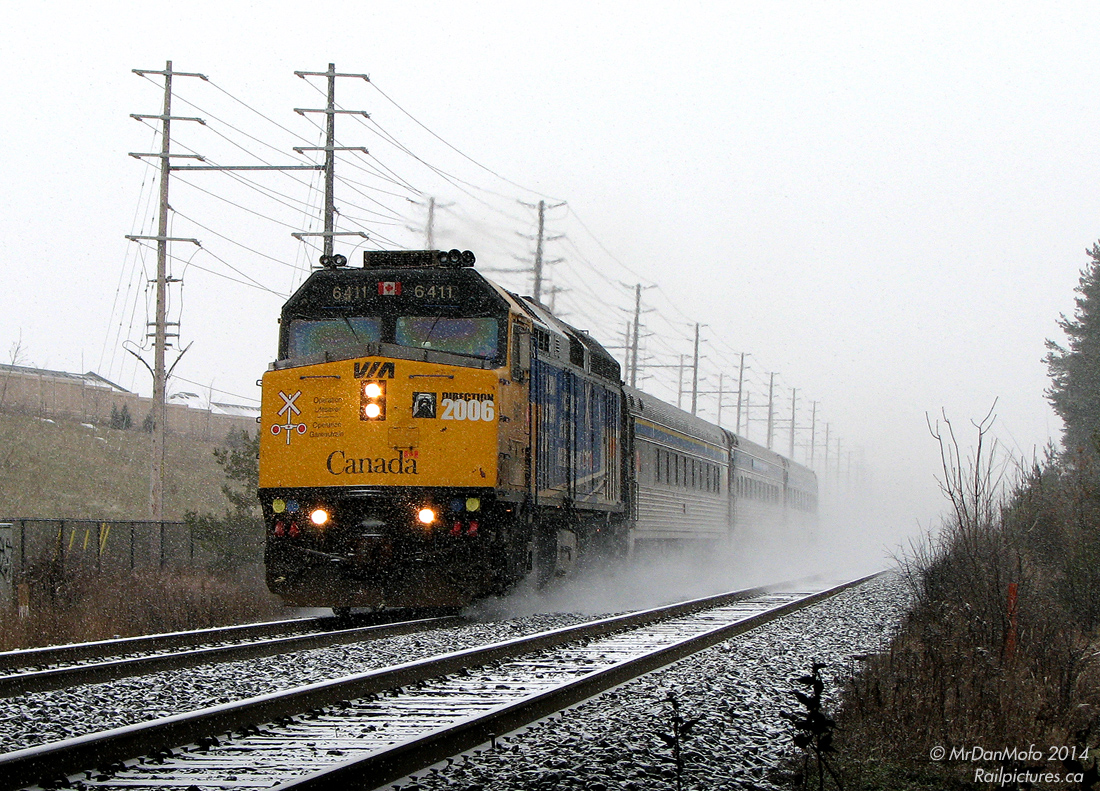 It's cold, it's snowing, it's Sunday, and we're freezing our bunions off. Initially braving the weekend winter weather to catch a hot Goderich Exeter Railway export special with what turned out to be a single boring FLP Class 66 for the UK (which of course happened to speed by just as we walked in to our photo spot), it was decided to stick around and wait for the regular afternoon VIA, and whatever else may be around. Naturally at this time it began to snow. But when life gives you snow, you make use of that brand new bridge the city has just finished to wait under.

After half an hour of accumulation, a set of headlights suddenly comes into view in the distance. Rapidly advancing through the white abyss, Operation Lifesaver painted 6411 accelerates VIA 85 out of downtown Brampton, on time, with the F40 and three Budd cars kicking up a trail of freshly fallen snow in their wake. Just as quickly as it appeared, it was gone - returning the scene back to quiet falling snow.