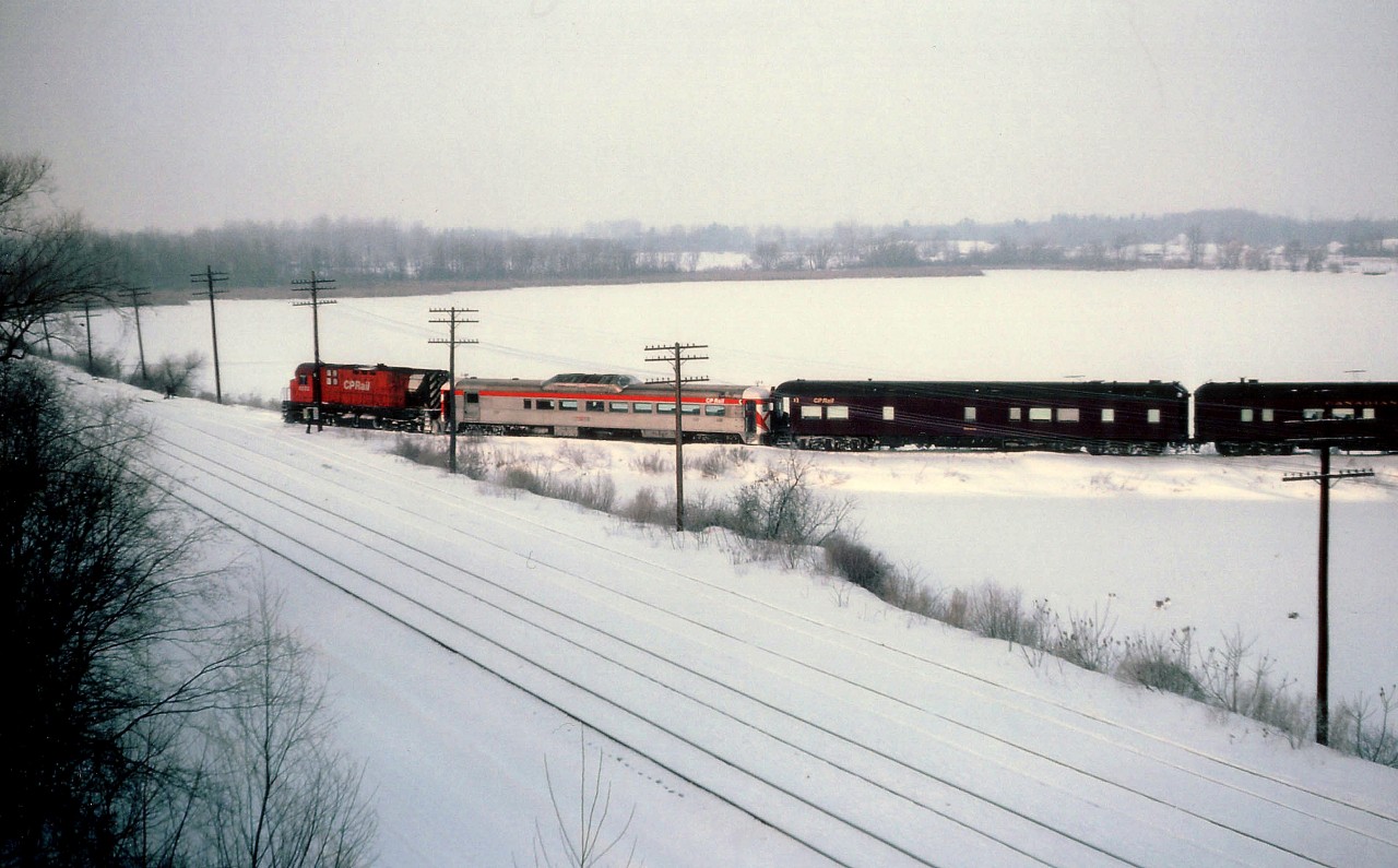 It may be hard to imagine from this view, but this was one of the coldest, windiest, most raw winter days that I had ever been out in. One camera froze up, but thankfully the other persevered. I am open to the elements, standing on the old LE&N bridge over the CASO at Waterford, watching a CP 'important dude' Special, those on board 'inspecting' new trackage which gave TH&B/CP an easier route for the Stelco Steel Train from Hamilton to Nanticoke. (In July of 1983 CP purchased a right-of-way through the Township of Townsend and laid a gentler grade track from the old Waterford Sub mile 78.9 to the x-LE&N Simcoe Sub. mile 35.3.) The TH&B connection at Waterford was in the form of a Wye, east, and west (pictured) legs with CASO being the south.