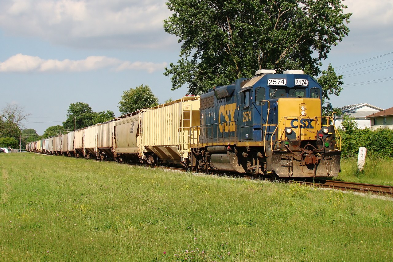 As I was heading north for a week long camping trip, I was driving through Wallaceburg and caught this local creeping along John Park Line, so I chased it through town. Here CSX GP38-2 2574 leads a lengthy train pass the former site of the Wallaceburg Station.
