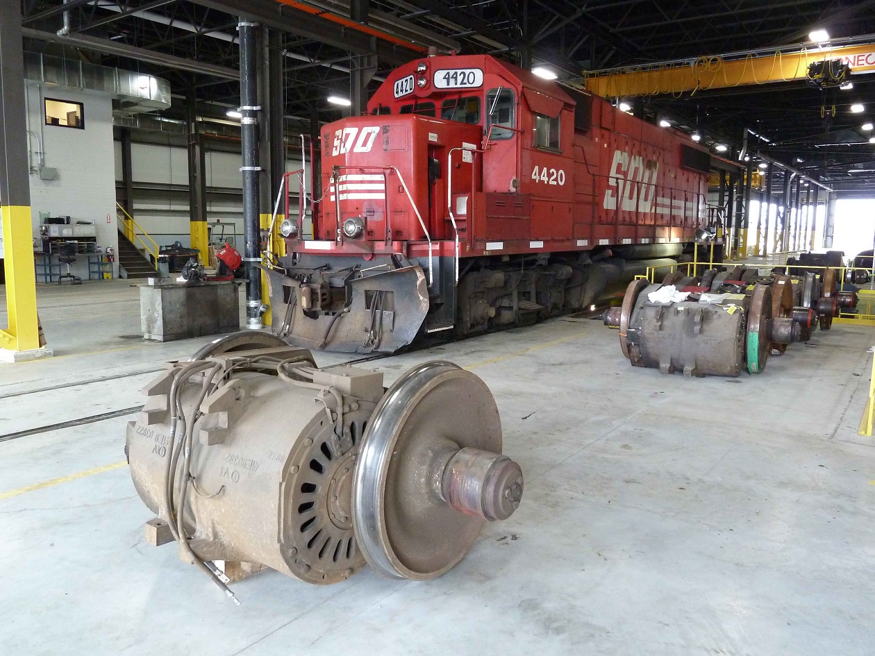 Soo GP 38-2 awaits wheel work at the newly opened plant two, truck and wheel shop at againcourt yard. With AC motors being stocked for upcoming GE work.
