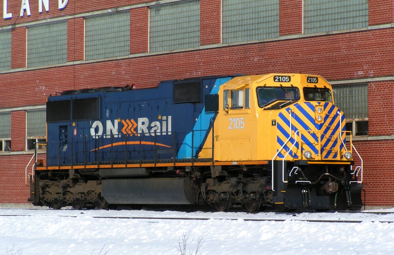 Ontario Northland SD75I #2105 sit's outside the North Bay diesel shops shining in the sun. The unit was in a logging truck accident back in dec of 2012 and after a year in the shops it was released with a new nose job and safety strips.