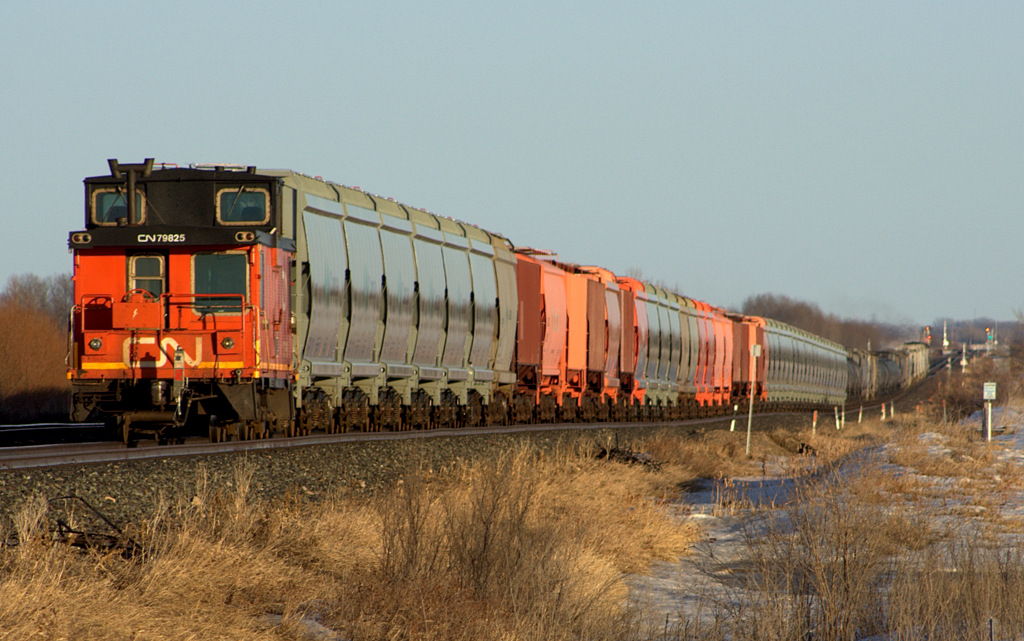 A rare site these days, A caboose on a mainline potash train crosses the not so flat prairies.
