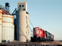 The "Chatham Wayfreight", with CP 8237 in command, hustles it's short train, including 2 hoppers, a 40' insulated boxcar, and a caboose, through Tilbury as it heads back to Windsor after a busy day back in December of 1991.