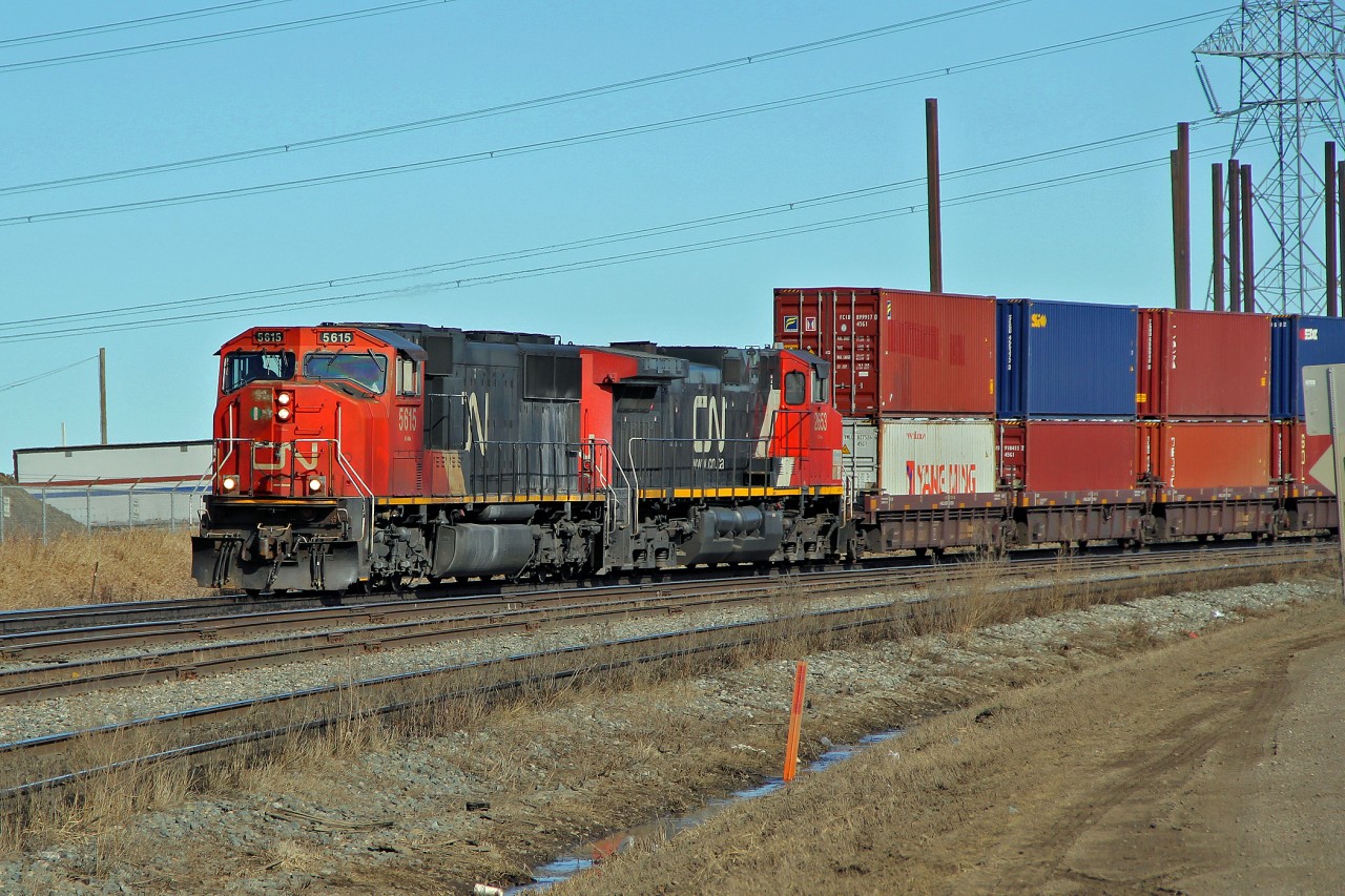 SD70I CN 5615 and DASH9-44CW CN 2653 ease a westbound intermodal through Clover Bar.