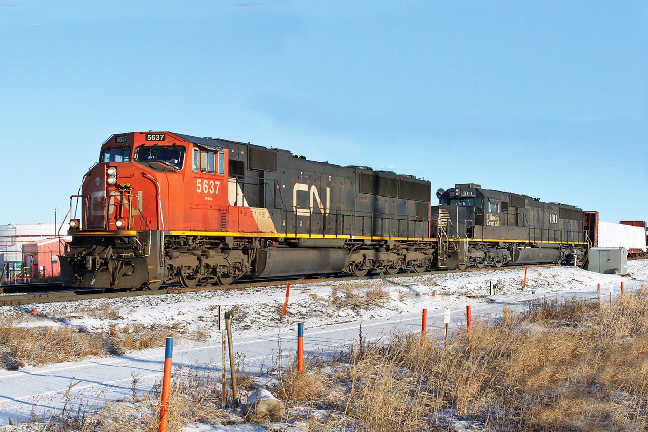 SD75I CN 5637 and SD70 IC1011 head west through Clover Bar approaching Edmonton.  CN 5637 is no longer on the roster having been retired in January 2012 after being hit by runaway coal cars near Hinton.