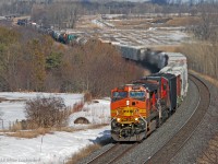 Having crested the climb from Port Hope, X321's train drops through the sag at is approaches Newtonville Road behind BNSF 4777 and CN 2116. 1537hrs.
<br><br>
In the distance you can see the tail of VIA #44 just before the tracks curve out of sight. It is stopped short of the block signals at the Newtonville crossovers waiting for traffic to clear so it may proceed. With rail replacements taking place on the North Track between Newtonville and Cobourg, everything is being funneled over the South Track, making for some significant delays on what is normally a fairly fluid line. VIA #44 got off lucky. Earlier, VIA #64 fared much worse, having sat at Newtonville for over an hour for CN X371, CN 107, VIA 643, CN 305 and CN 121.