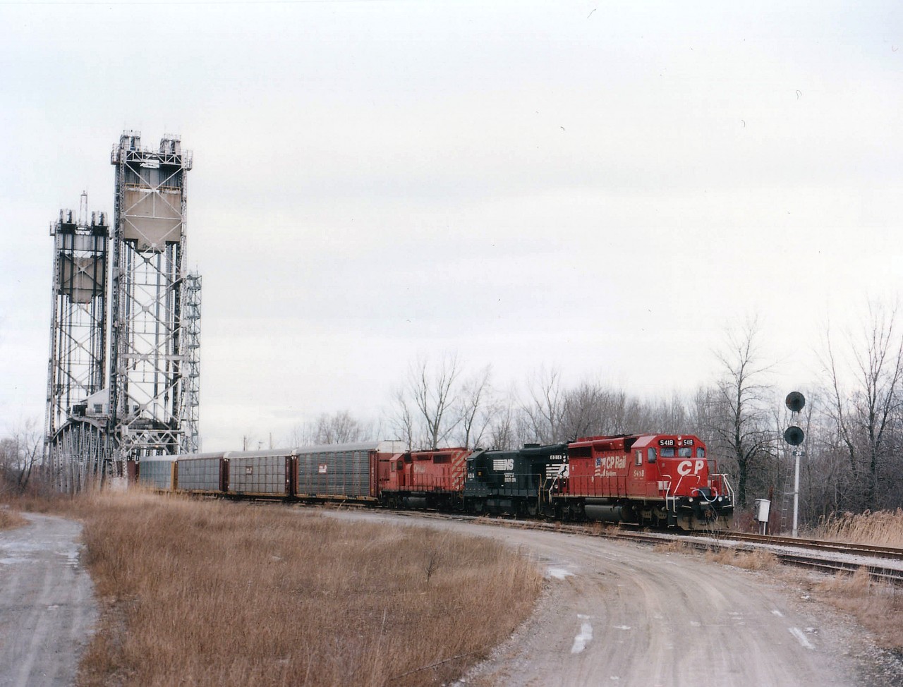 Due to bridge work on Bridge 6, the regular CN mainline bridge over the Welland Canal, trains approaching while a work block was in progress were rerouted via the Thorold Sub and bridge 10 to Port Robinson and onto the CN Stamford Sub., bypassing Niagara Falls altogether. I'm not aware as to how many trains did this route, but I noted four #328s between Nov 27/96 and Jan 22/97. I heard of no CNs going this way. And the detours were only sporadic, as after the first on Nov 27th, I noted Dec 4,5 and 6 (as well as many other #328s) going the regular route thru Niagara Falls. So the Thorold run would come under 'rare mileage'. Especially for anything other than CN. I understand maintenance and repair costs excessive, the bridge 10 shown here was dismantled by the Seaway Authority not long after this photo was taken. Power is CP 5418, NS 4014 (B23-7) and CP 5600.