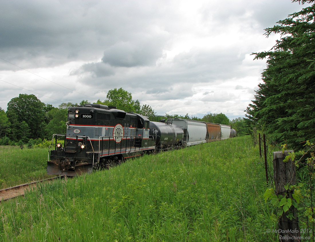 Heading north under questionable skies, CCGX 1000 rounds the bend north of Inglewood with five cars in tow, hightailing it through the scenic Caledon countryside back to Orangeville with no work enroute. Next will be the five-mile-an-hour Forks of the Credit bridge before heading on to Cataract, Alton, Melville and finally home.