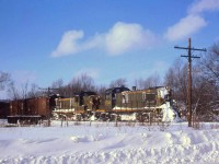 CN RSC-13 units 1733 and 1706 haul a freight train at Harriston ON, in January 1963. Harriston was Mile 5.01 on the CN's now-abandoned Owen Sound Subdivision (the line from Palmerston to Owen Sound), and junction point with the Southampton Sub (Harriston to Southampton). While the new CN noodle logo and image was introduced 2 years earlier as evident by the boxcar on the far left, the older green/yellow livery with the maple leaf herald still has a noticeable presence. <br><br> The RSC-13 was a CN-only model built by MLW in the mid-late 50's, with an RS3-style hood and A1A trucks but using the older 1000hp 539T engine - essentially their version of a GMD GMD-1. They were intended for light rail and branchline use, and while many worked out of Stratford and Toronto in their early years, they were more known for handling freight on Prince Edward Island in their later years (when retired, the A1A trucks from many went under RS18's upgraded for branchline service as RSC14's). <br><br> <i>Geotagged location not exact</i>.