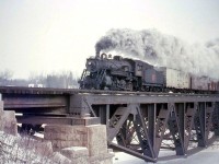CNR 2-8-0 2602 crosses the Credit River at Port Credit with a freight in tow, in March 1957. Built in 1907 by MLW for the Grand Trunk, this N4a-class "Consolidation" only had about a year left until she was scrapped. The large steel bridge over the Credit River is mileage 13.27 on the CN's Oakville Sub, and still spans the southern tracks today.