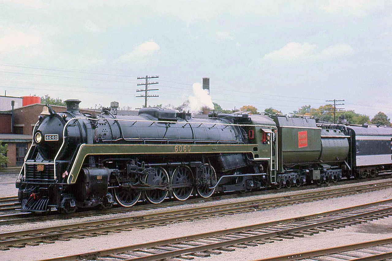 During a steam excursion on September 21st 1975, CN's "Bullet Nose" 4-8-2 Mountain 6060 is seen here in Guelph ON uncoupled from her train. Part of a 20 locomotive order from MLW in 1944 (U1f class), the 6060 currently resides out west at the Rocky Mountain Rail Society in Alberta, in operating condition.

Geotagged location not exact.
