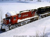 Following the behind the <b><a href="http://www.railpictures.ca/?attachment_id=14417">CP Plow extra</a></b> in the previous photo, a snow-covered CP C424 4210 and leased B&O GP38 4803 head a northbound freight up the Owen Sound Sub, south of Owen Sound. Probably an extra freight as there's a white flag on the engineer's side of the lead unit; presumably snow drifts took the other one.
