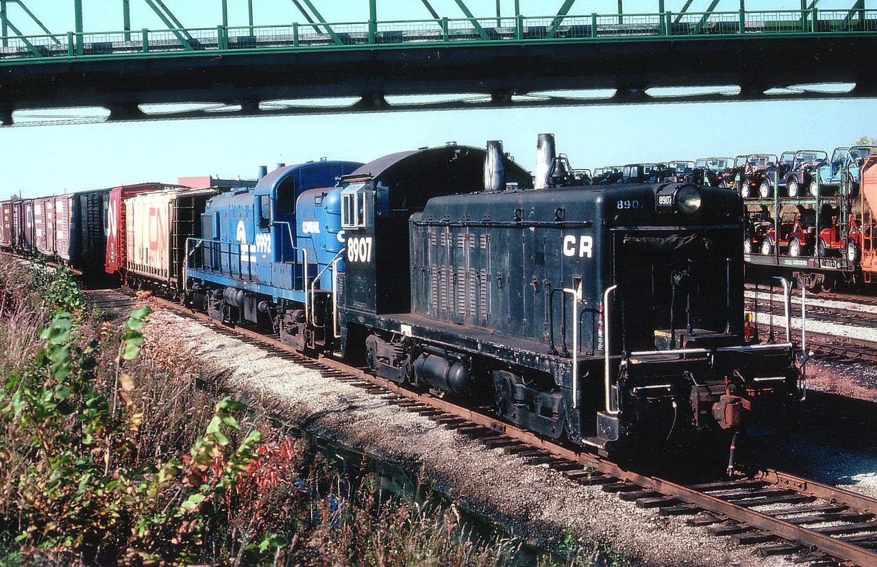Fooled!!! Thinking I had plenty of time to catch the transfers this day, I arrived just as the Conrail set was acting on their green signal and heading Stateside. So jumped out and grabbed this shot under the Central Av bridge. The train is seen coming off the old connection to the former CN Dunnville sub that ran along the south/west side of the Diesel Shops and roundhouse. Power is CR 8907 and 9992, an RS3M from the 9960-9999 series. The leader has me puzzled. Thinking it is an NW2, I look in the only CR roster list I have from 1982 and 8907 is listed as an SW7. Supposing the original 8907 was a former Peoria & Eastern then retired and a "new" 8907 took its place? Don't have a P&E roster, but I'll go with that.  Anyway, quite the unusual combination, even for Fort Erie.