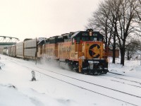 Snowy and blustery winter afternoon at Fort Erie as B&O 4341 and 4115 haul the daily transfer from F.E. yard over to Buffalo. Central Av bridge in background and the relatively new flat roofed Michigan Central station can just be seen at the right of the lead unit. Station is history. It ran out of usefulness when the CP/TH&B Budds ceased operation thru here in 1981.