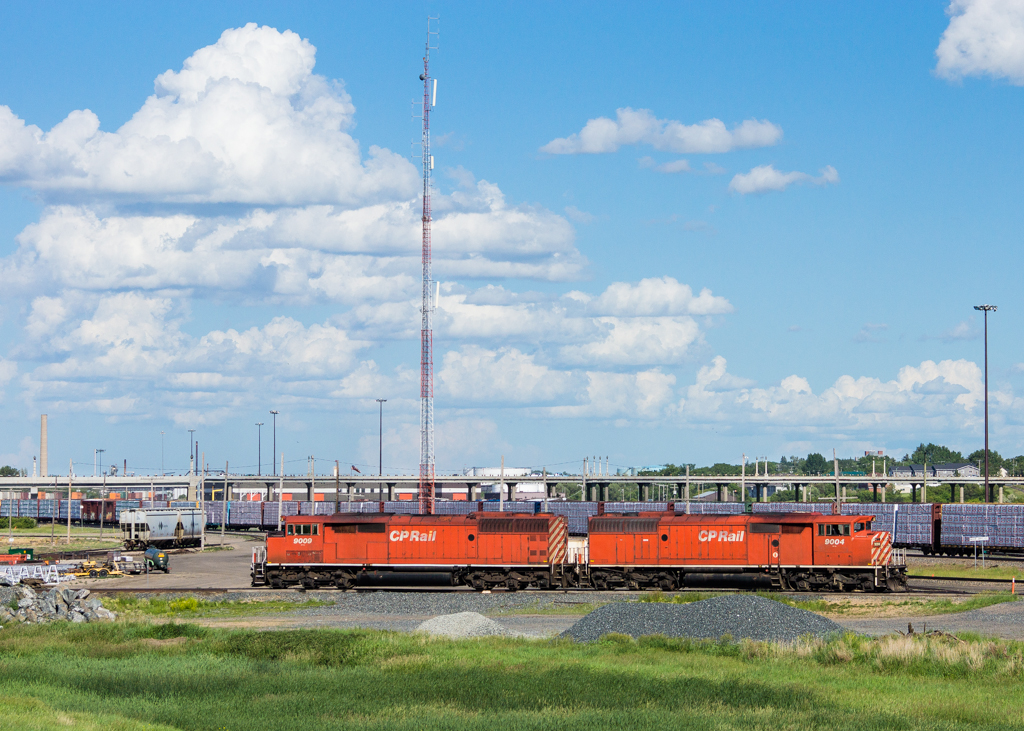 A pair of Red Barns (9004 and 9009) bask in the sun on the north side of Moose Jaw yard.