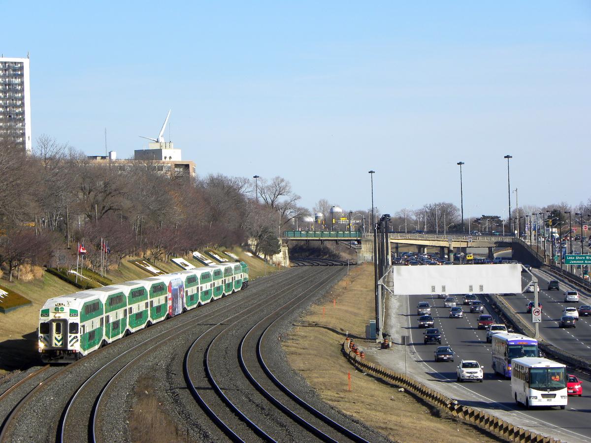GO Cabcar #252 leads a Westbound GO Transit commuter train on the Lakeshore West Line, or CN Oakville subdivison, which is no longer used by Canadian National trains, and only has GO Transit, VIA Rail, and Amtrak action. At about mile 10 counting from Toronto's Union station, lays Sunnyside pedestrian bridge, which is a great spot to photograph passenger trains in the area. The Gardiner Expressway lays to the right, where we see other modes of transport such as busses, cars, and trucks zooming past.