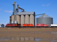 CP 8648 with GP9's 1690 & 1549 in tow, heads westbound past the grain elevator at Haycroft. The Geeps are probably headed for the scrapper.