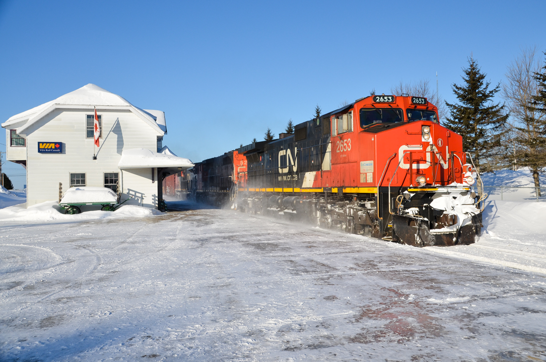 CN 2653, CN 5263 and CN 2322 are eastbound past the Hervey Jonction station with CN 368 on the scenic Lac St-Jean sub on a beautiful but frigid morning. For more train photos, click here.